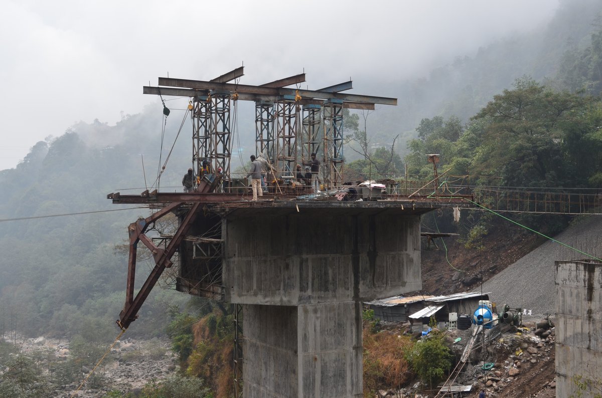 Bakcha Khola Bridge — Form traveler on pier with misty mountains